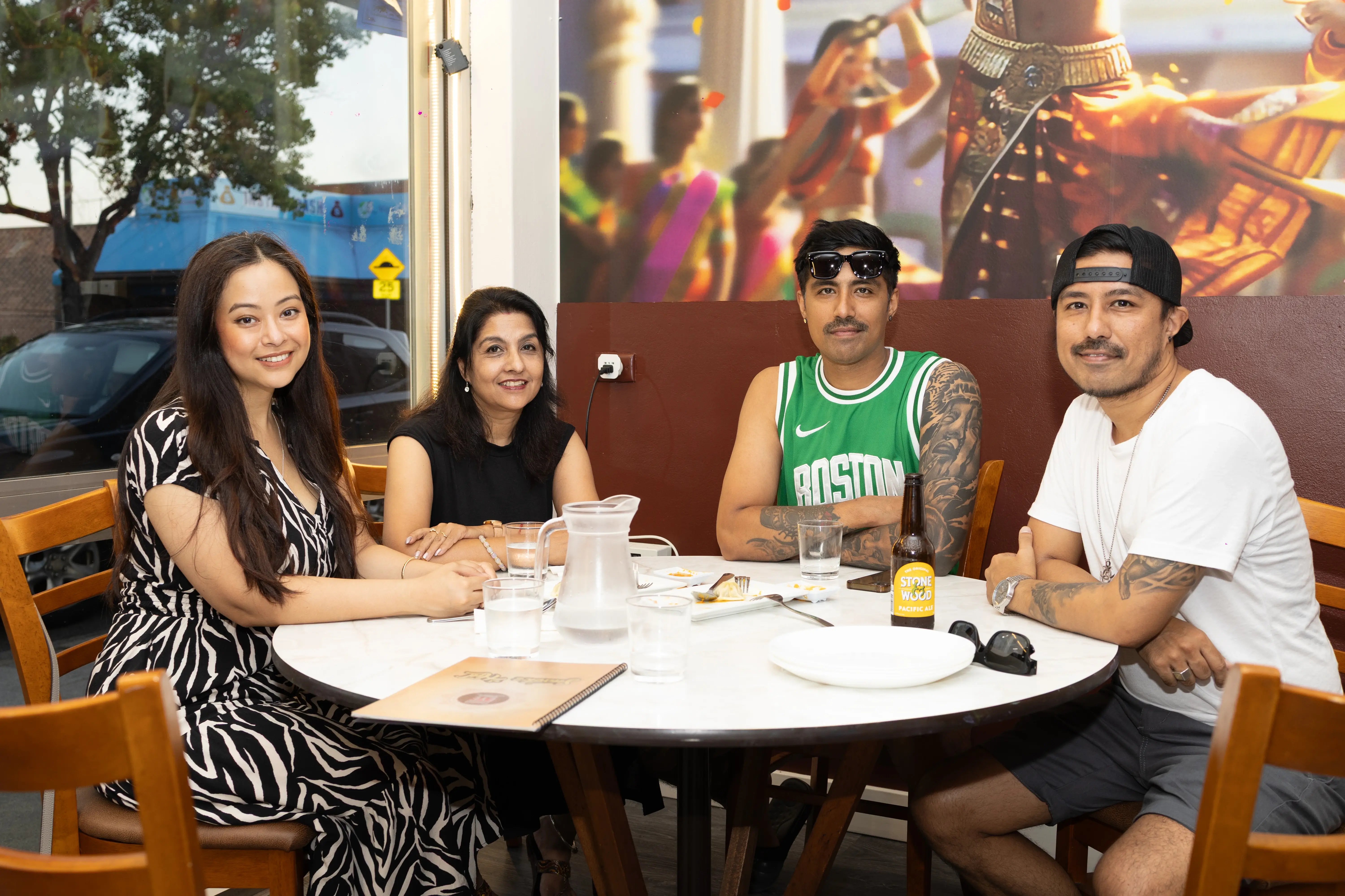 A group of four friends enjoying the restaurant ambiance, seated in semi-formal attire. Two are women and two are men, all smiling at the camera and having fun at Third Eye Windsor, 515 George St, South Windsor NSW 2756.